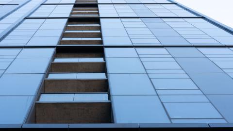 A glassy high-rise apartment tower with in-set balconies.