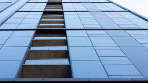 A glassy high-rise apartment tower with in-set balconies. 